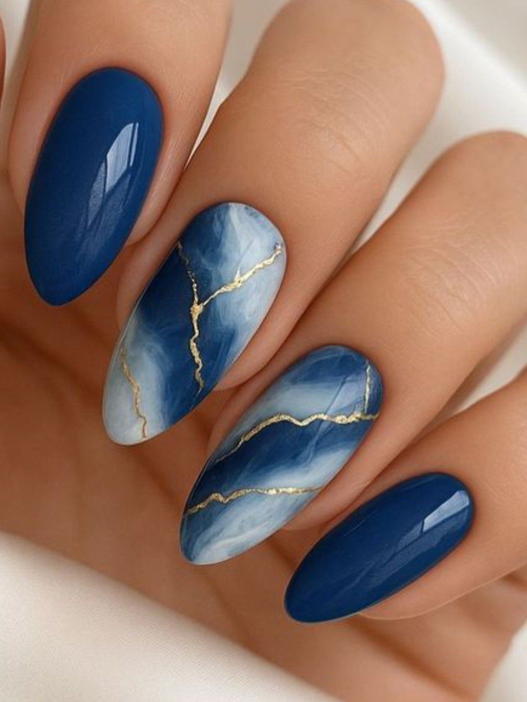 Marbled blue and white nails with delicate gold veining