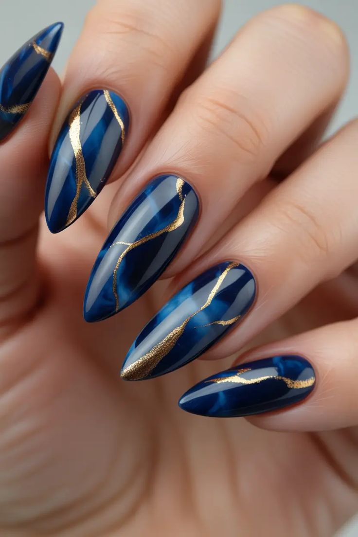 Navy marbled almond nails with hand-painted gold stripes