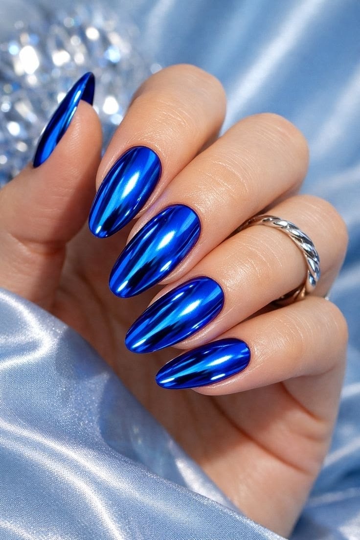 Mirror cobalt blue chrome stiletto nails on pale blue satin with crystal cluster