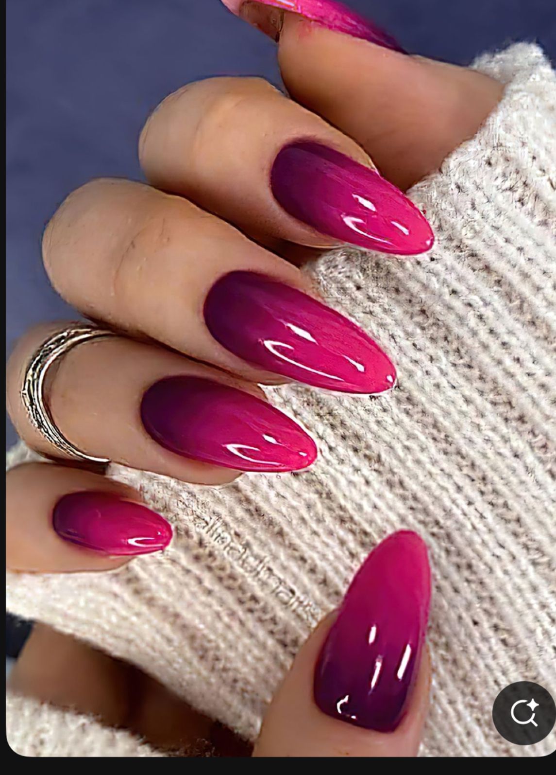 Hot pink to magenta ombré almond nails on a cream knit sweater